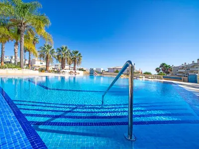 a large swimming pool with palm trees in the background at Apartment Penthouse Milea by Interhome in Patroves