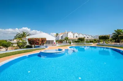 a large swimming pool with a house in the background at Villa Baya - Great family complex with communal pool in Albufeira