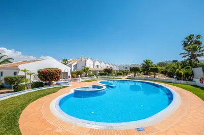 a swimming pool in a yard with houses in the background at Villa Baya - Great family complex with communal pool in Albufeira