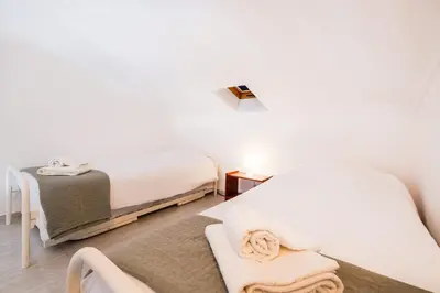 a white bedroom with two beds and a table at Apartment Marlena - complex great for families in Albufeira