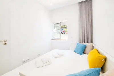 a white room with a couch and a window at Apartment Tanta - located at the gates of the old in Albufeira