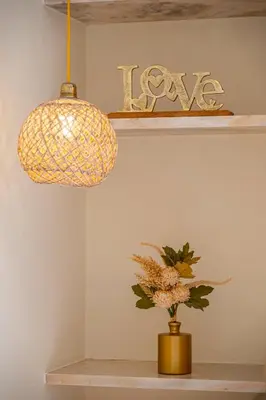 a pendant light and a vase with flowers on a shelf at Apartment Vento in Albufeira
