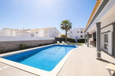 a swimming pool in front of a house at Villa Redonda in Albufeira