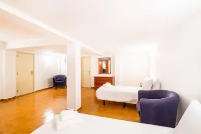 a bedroom with a bed and two chairs in it at Villa Redonda in Albufeira