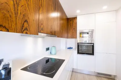 a kitchen with white counters and wooden cabinets at Apartment Riu - Close to bars shops and restaurants in Albufeira