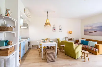 a kitchen and living room with a table and chairs at Apartment Mayah - Albufeira marina in Albufeira