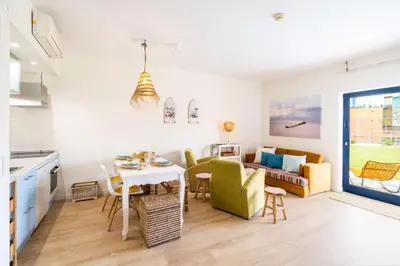 a kitchen and living room with a table and chairs at Apartment Mayah - Albufeira marina in Albufeira