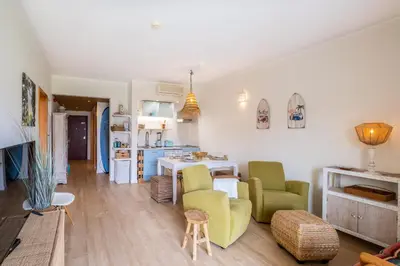 a living room with green chairs and a kitchen at Apartment Mayah - Albufeira marina in Albufeira