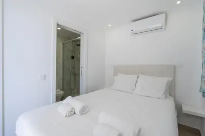 a white bed with two towels on top of it at Marina Vision Vilamoura in Vilamoura