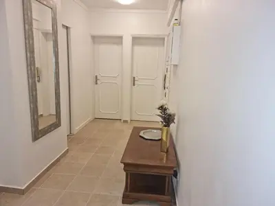 a hallway with a table and a mirror and a door at Casa Jasmim in Faro