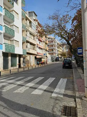 a car driving down a city street with buildings at Casa Jasmim in Faro