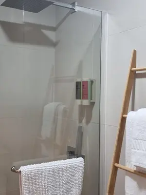 a glass shower door in a bathroom with towels at Casa Jasmim in Faro