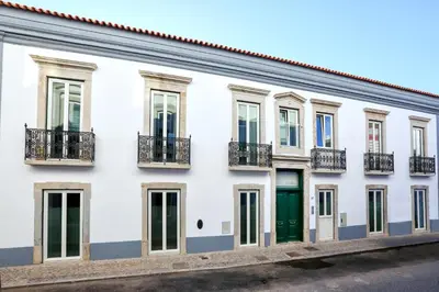 a white building with green doors and windows at GREEN FARO, MODERN DUPLEX with A BLISS TERRACE in Faro
