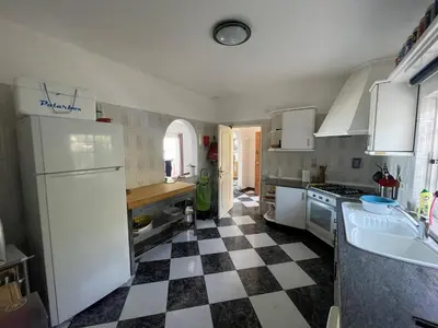 a kitchen with a black and white checkered floor at Cabana do Monte in Santa Bárbara de Nexe