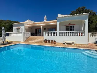 a villa with a swimming pool in front of a house at Cabana do Monte in Santa Bárbara de Nexe