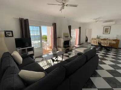 a living room with a black couch and a checkered floor at Cabana do Monte in Santa Bárbara de Nexe