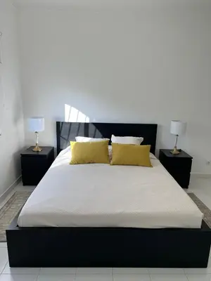 a bedroom with a large bed with yellow pillows at Pateo AL Albufeira in Albufeira