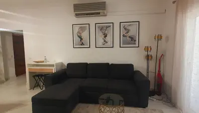 a living room with a black couch and pictures on the wall at Pateo AL Albufeira in Albufeira