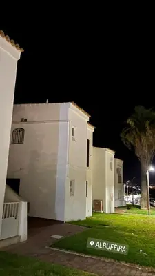 a white building at night with a palm tree at Pateo AL Albufeira in Albufeira