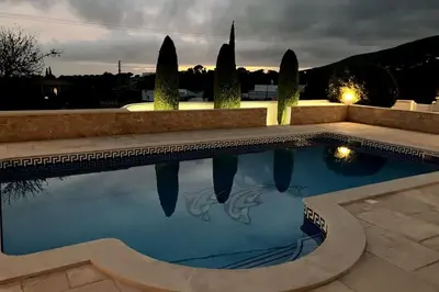 a swimming pool with its reflection in the water at Vila Lana - Heated pool - Sea view - Two independent floors in Faro