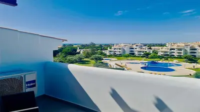 a balcony with a view of a pool and buildings at Green Valley 03- CleverDetails, Monte Verde, lux, distant sea view, 3 bedroom, 4 saltwater pools in Vilamoura