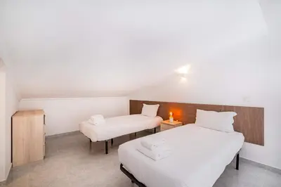 a room with two beds and a chair in it at Marina Vista Retreat in Albufeira