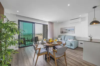 a dining room and living room with a table and chairs at Terracos de Quarteira II Eden by Real Properties in Quarteira