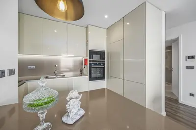 a kitchen with white cabinets and a glass bowl on a table at Terracos de Quarteira II Eden by Real Properties in Quarteira