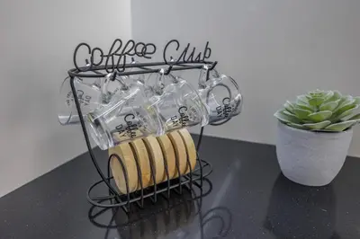 a black wire drying rack with cookies and a plant at Terraços de Quarteira II Frolic by Real Properties in Cavacos