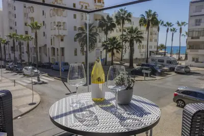 a table with two glasses and a bottle of wine at Terraços de Quarteira II Frolic by Real Properties in Cavacos