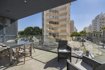 a balcony with a table and chairs and a building at Terraços de Quarteira II Frolic by Real Properties in Cavacos