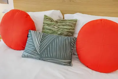 a bed with two red cushions and two pillows at Terraços de Quarteira II Frolic by Real Properties in Cavacos