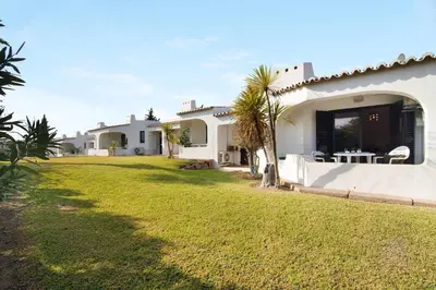 a backyard of a house with a grass yard at Ema Clube em Albufeira in Albufeira