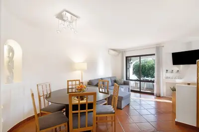 a living room with a table and a dining room at Ema Clube em Albufeira in Albufeira