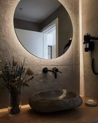 a bathroom with a stone sink and a mirror at Casa Pateo in Albufeira