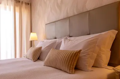 a bedroom with a large bed with white pillows at Miradouro da Penha in Faro