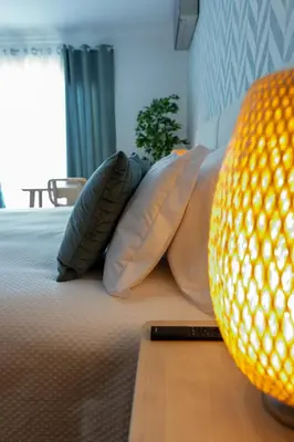 a bed with pillows and a lamp on it at Miradouro da Penha in Faro