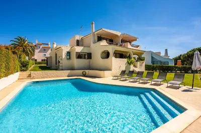 a large white house with a large driveway at Sunny Vilamoura Golf Villa with Private Pool in Quarteira