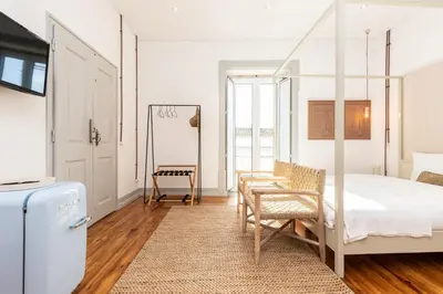 a bedroom with a bed and a table and chairs at Amália Boutique Suites & Studios - by @ rita´s place in Faro
