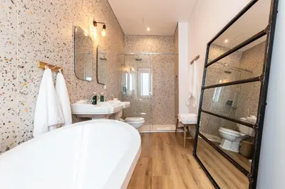 a bathroom with a tub and a sink and a toilet at Amália Boutique Suites & Studios - by @ rita´s place in Faro