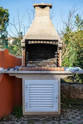 a brick oven with a door on top of it at 7+1 BEDROOM PRIVATE VILLA, HEATED POOL, GAMES, BBQ in Albufeira