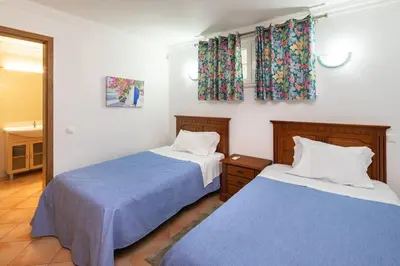 two beds in a bedroom with blue and white sheets at 7+1 BEDROOM PRIVATE VILLA, HEATED POOL, GAMES, BBQ in Albufeira