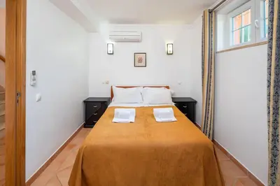 a bed in a room with two white pillows at 7+1 BEDROOM PRIVATE VILLA, HEATED POOL, GAMES, BBQ in Albufeira