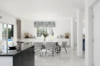 a white dining room with a table and chairs at Villa Olivia in Almancil