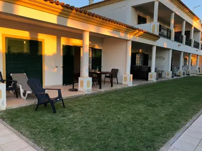 a house with chairs and a lawn in front of it at Casa Rachael in Albufeira