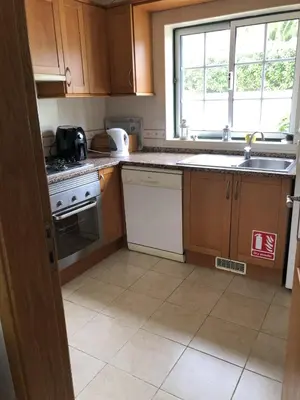 a kitchen with wooden cabinets and a sink and a window at Casa Rachael in Albufeira