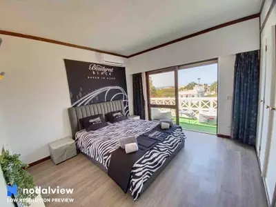 a bedroom with a zebra print bed and a large window at HIMALAYA ROOFTOP Sea VIEW in Albufeira