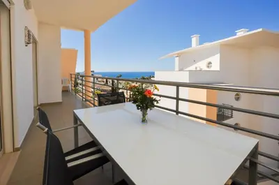 a balcony with a table and a view of the ocean at Encosta da Orada by OCvillas in Albufeira