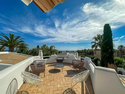 a patio with chairs and tables on a roof at Luxury Villa Heated Pool, walk to São Rafael Beach, Albufeira in Albufeira