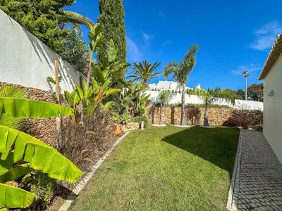 a garden with green grass and trees and a fence at Luxury Villa Heated Pool, walk to São Rafael Beach, Albufeira in Albufeira